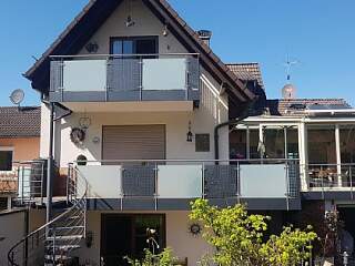 Balkongeländer aus Metall mit Glasfüllung und Außen-Spindeltreppe | &copy;Schlosserei Schott GmbH